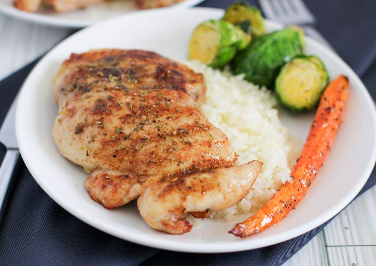 Chicken thighs on plate with veggies