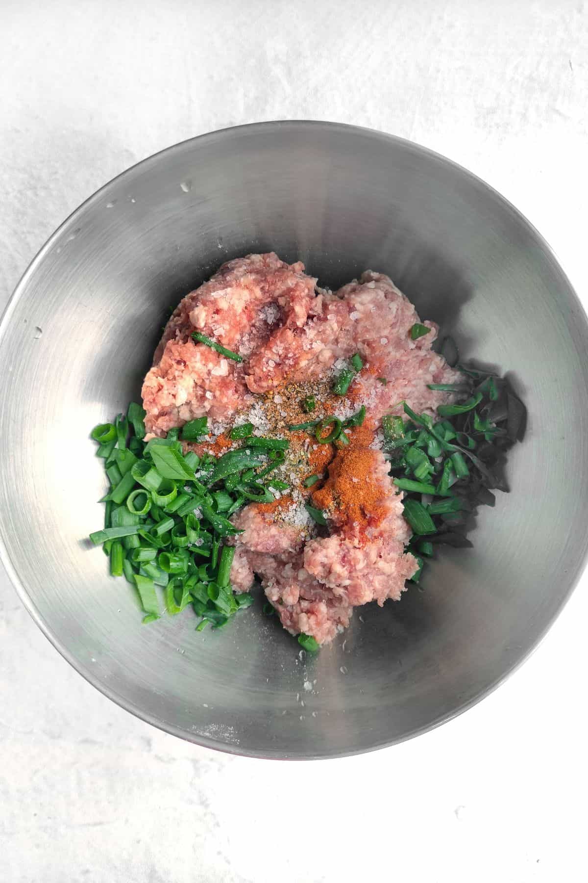Ground Beef in a mixing bowl. Add salt, pepper, spices and scallions