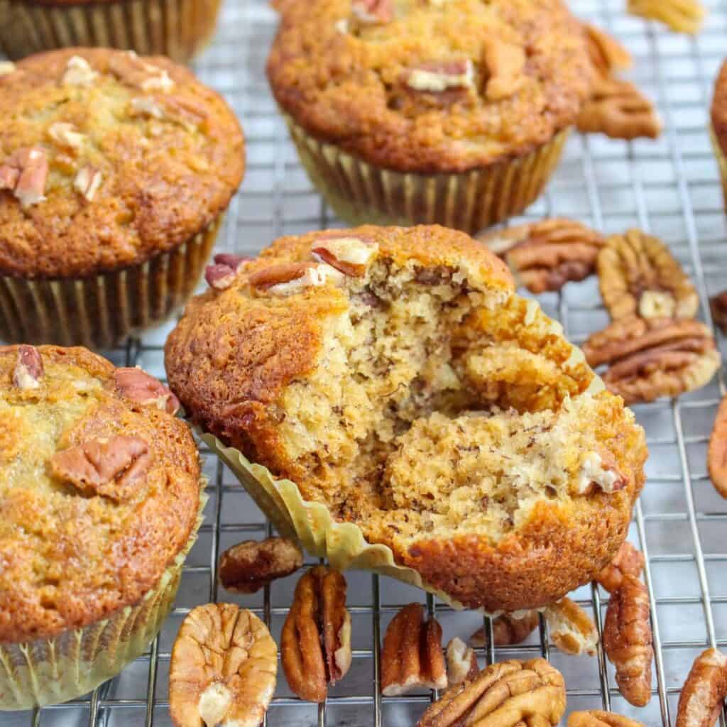 Banana Protein Muffins split in half on a wired rack.